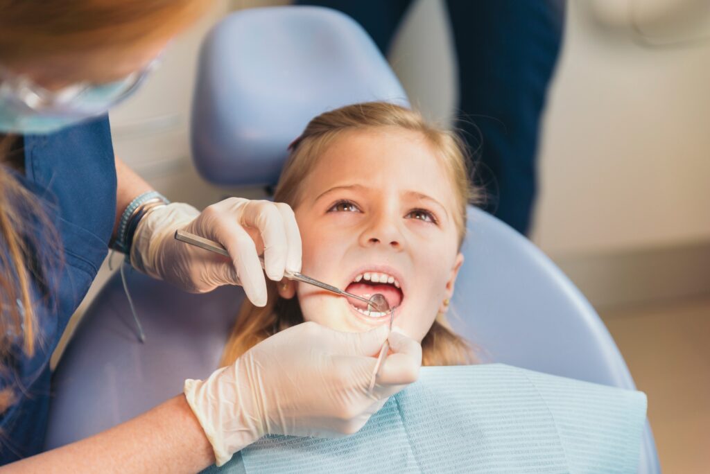 Dentists with a patient during a dental intervention to girl.