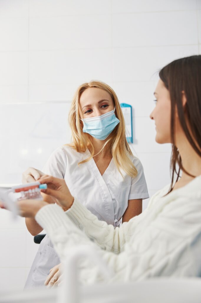 Friendly orthodontist taking away toothbrush from patient